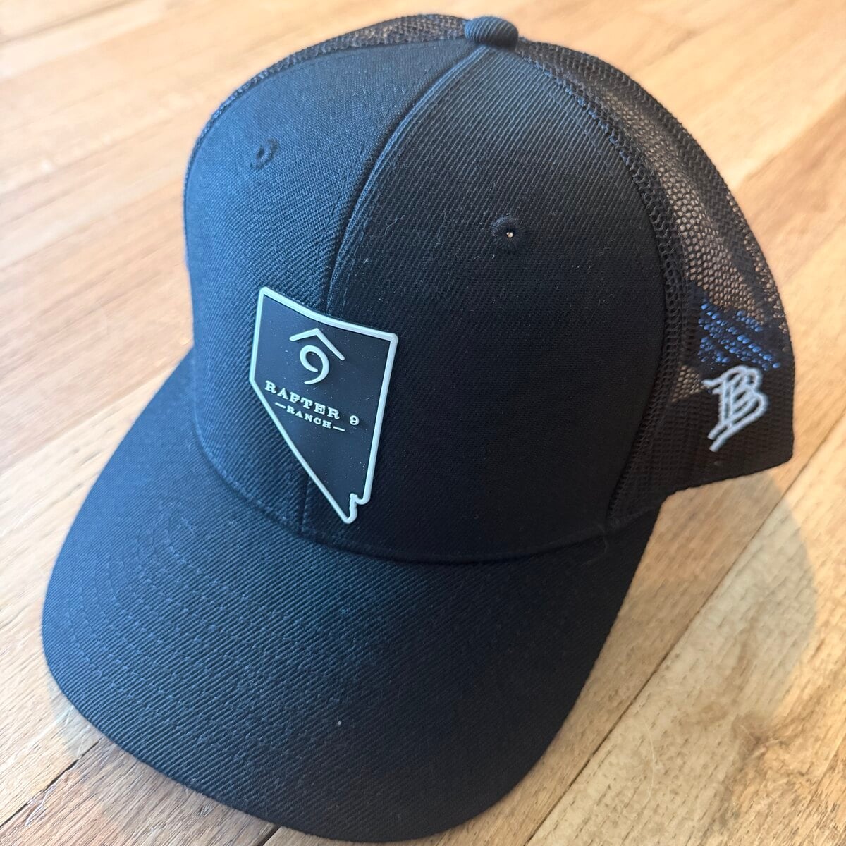 Black Rafter 9 Ranch Essential 300 trucker hat with the Nevada-shaped logo patch